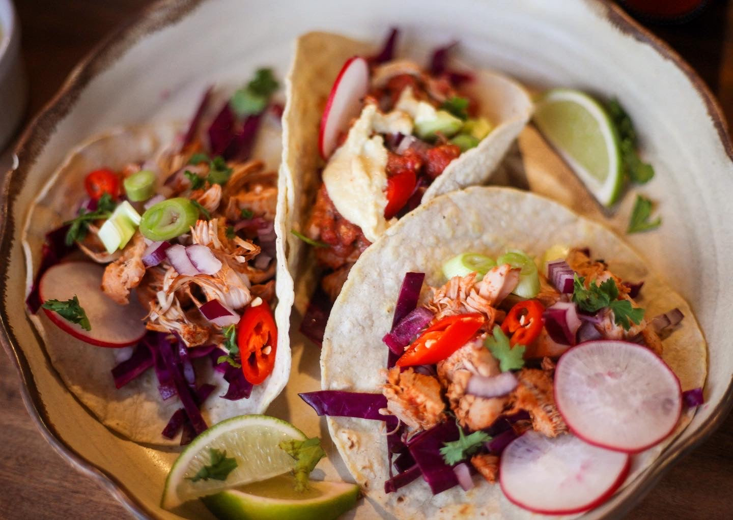 Tropical jackfruit soft tacos with ghost pepper salsa, and cashew cheese sauce.