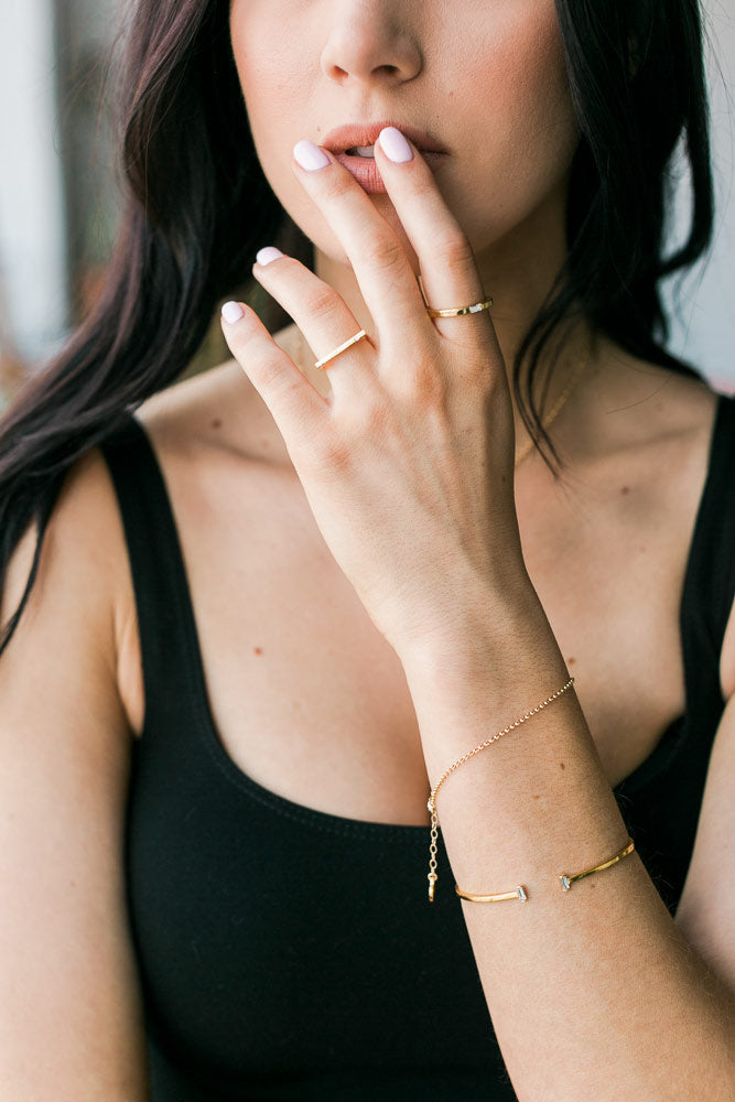 Woman with hand to lips wearing Katie Dean Jewelry Gold Rolo Bracelet