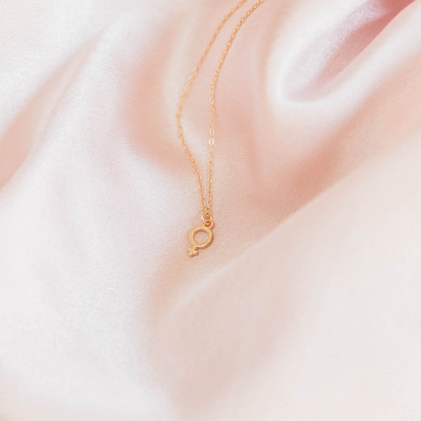 Gold Female Symbol Necklace on pink satin, dainty handmade necklace by Katie Dean Jewelry