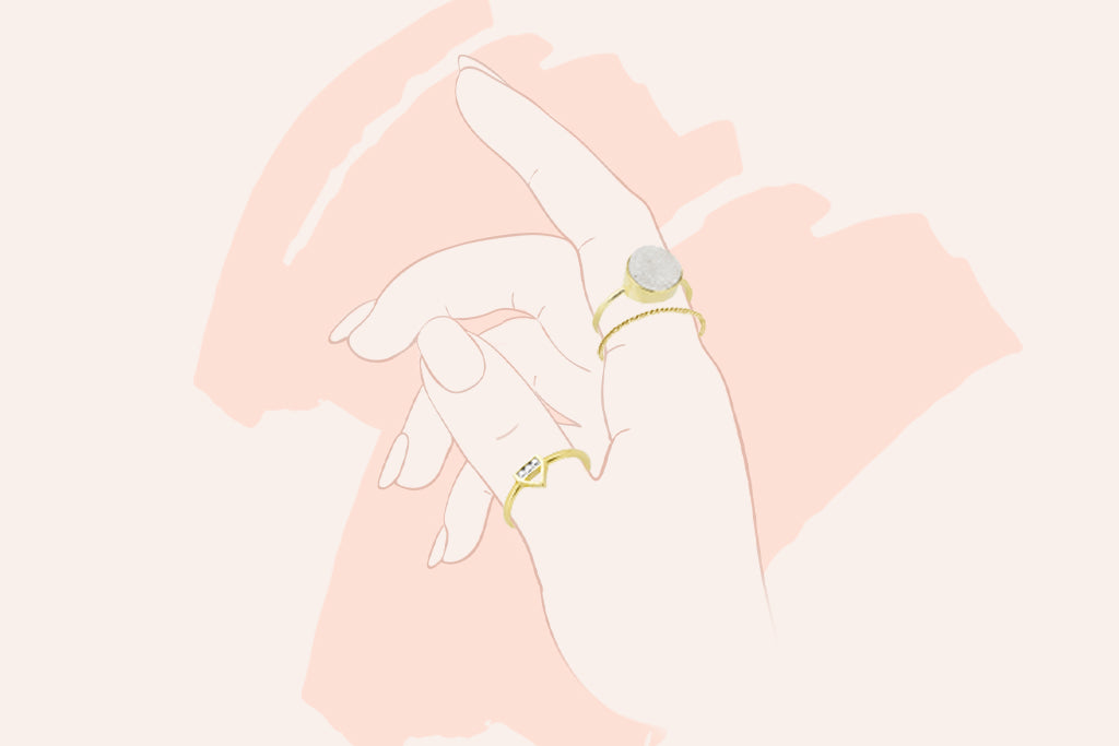 drawing of a hand, showing the thumb and pointer finger with Katie Dean Jewelry gold rings on each.