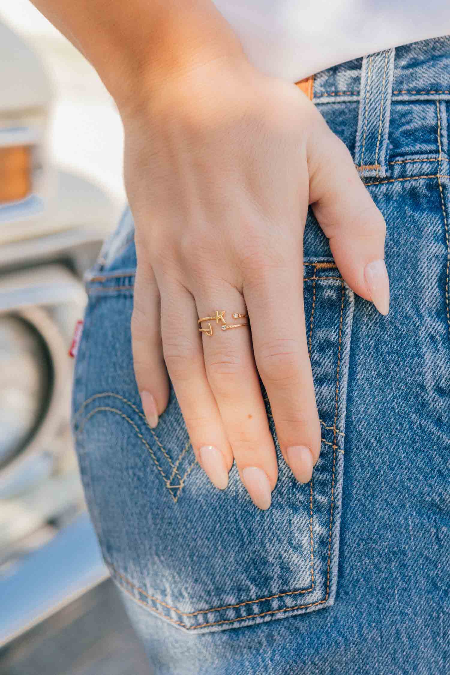 Woman's hand on jeans wearing Katie Dean Jewelry Initial Ring
