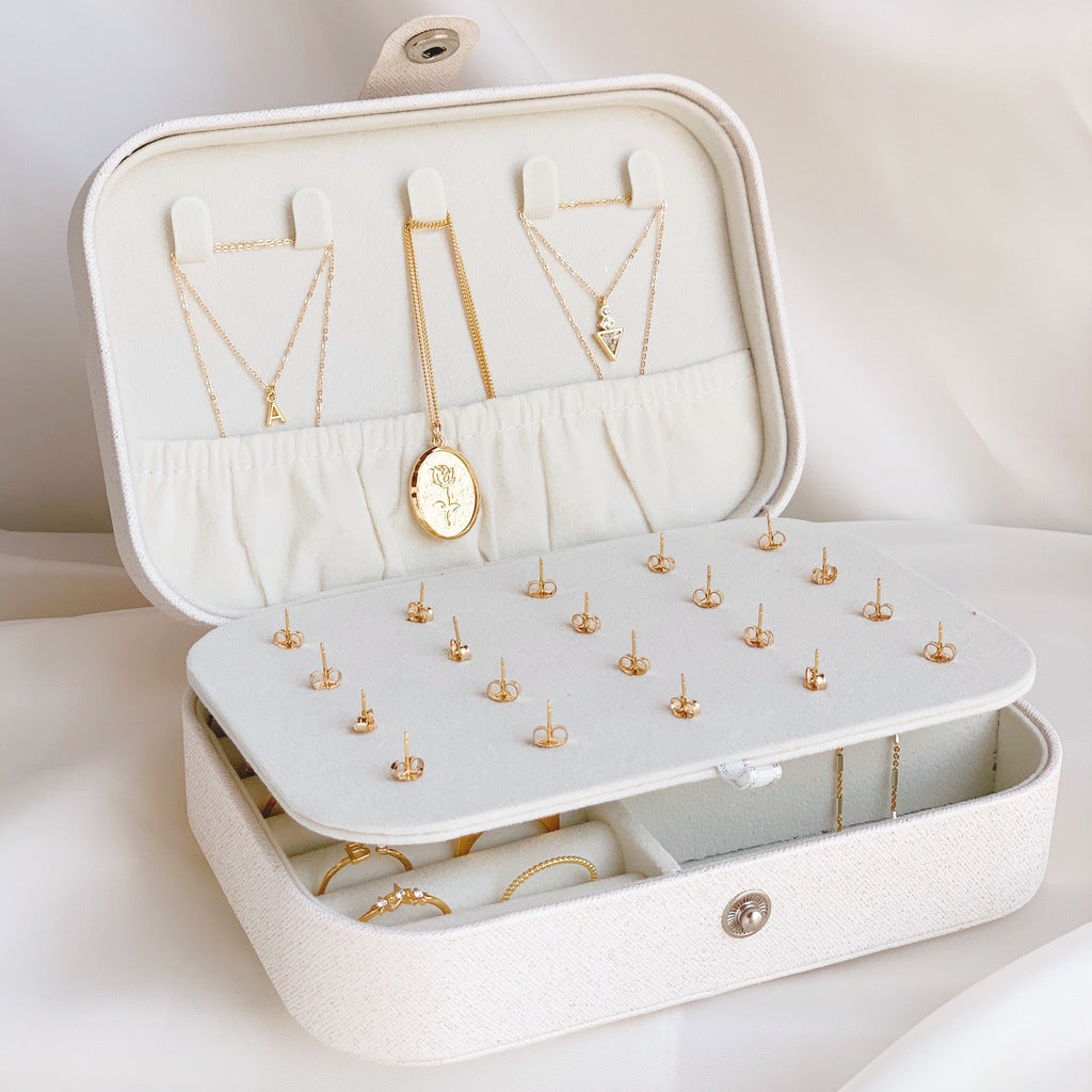 White jewelry case with dainty gold Katie Dean Jewelry necklaces inside.