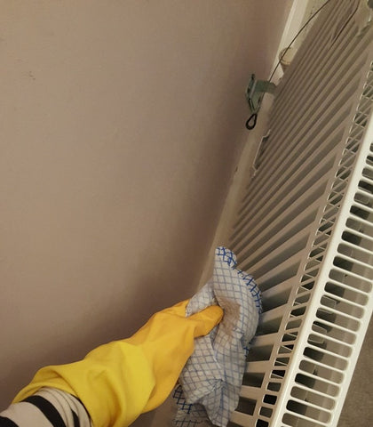 cleaning behind a radiator