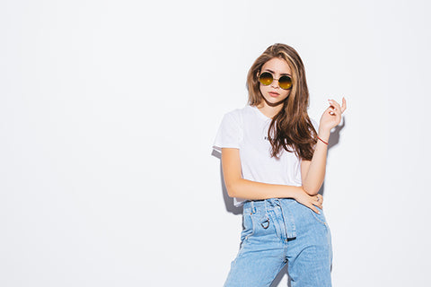 Woman in 90s inpired blank white t shirt high waisted denim jeans with sunglasses