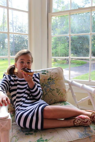 caroline eating donut in indoor patio in sumak kilim loafers, part of childrens shoes collection.