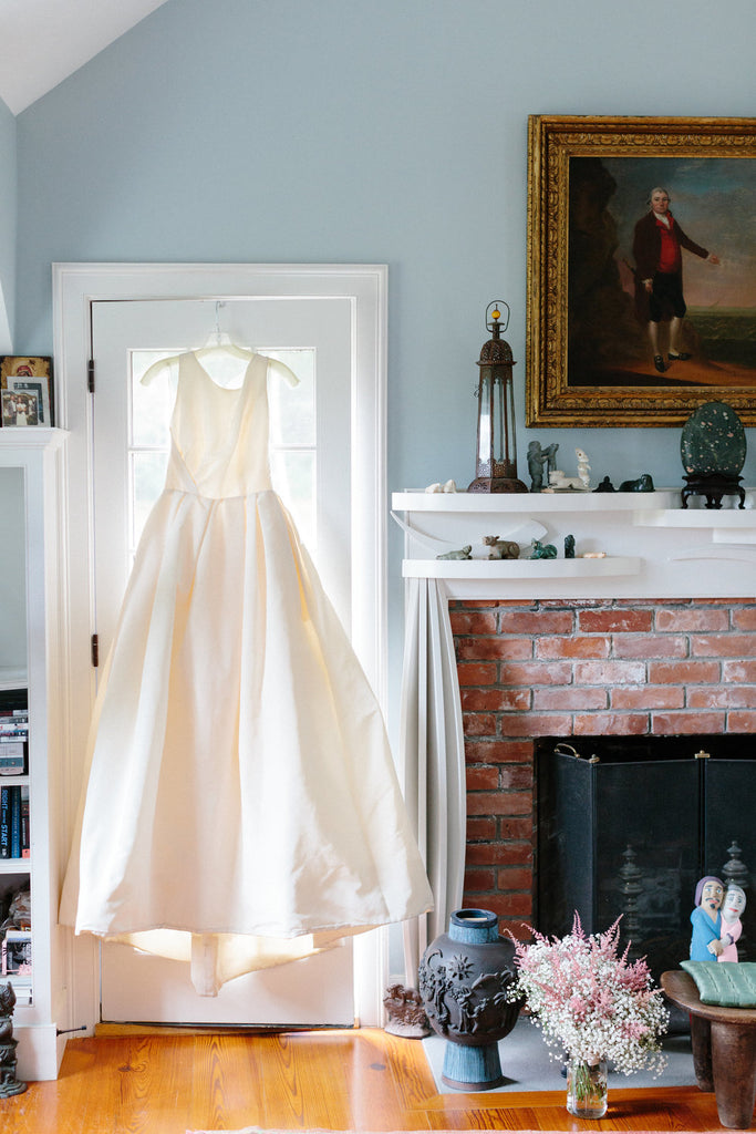 Milicent's wedding dress hanging up while she is getting ready.