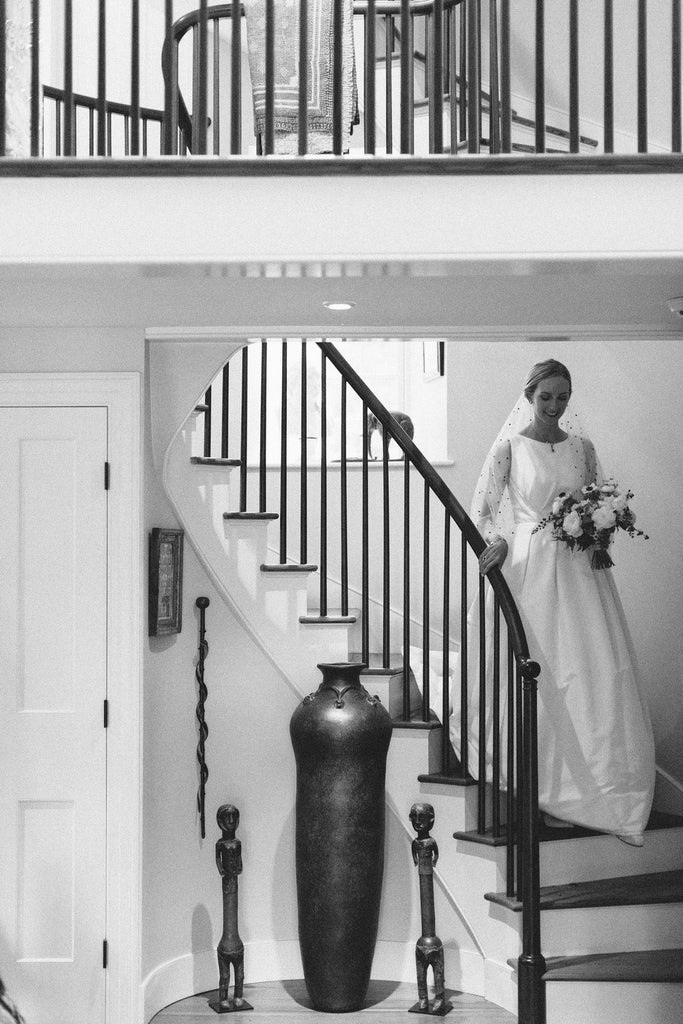 bride in her dress and pearl velvet slippers entering down the stairs