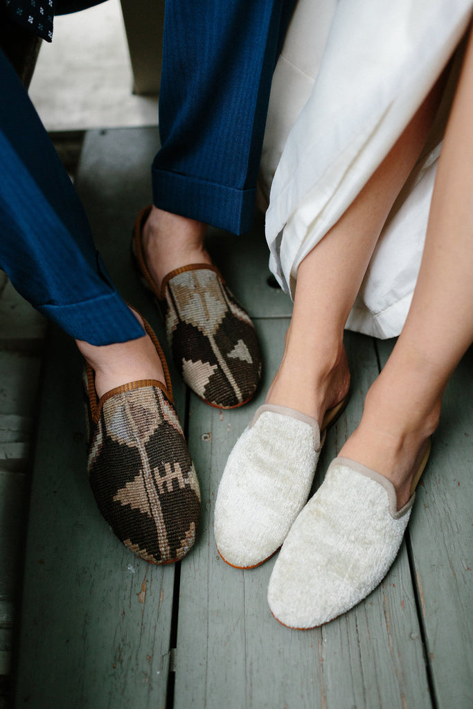 portrait of the grooms shoes, mens kilim loafers, and the brides shoes, pearl velvet slippers.