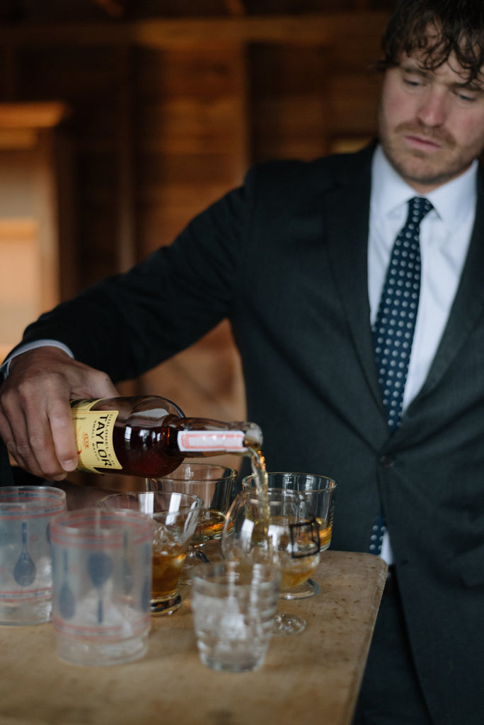 Drinks being poured as groomsmen get ready for the ceremony.