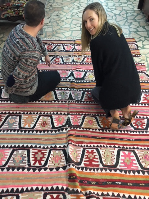 Milicent sitting on colorful kilim carpet in Istanbul. 