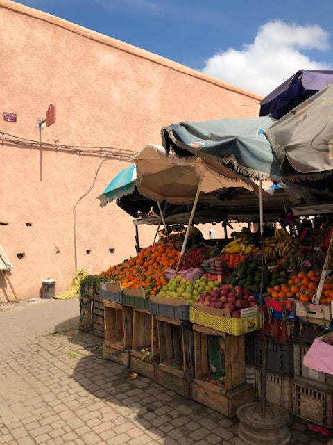 Colorful fruit market covered by umbrellas in Marrakech.