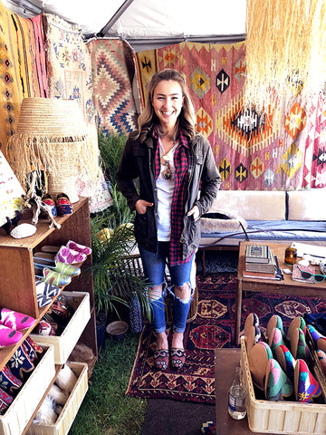 brimfield antique market customer in womens kilim slides and womens kilim loafers surrounded by kilim carpets and mens kilim loafers.