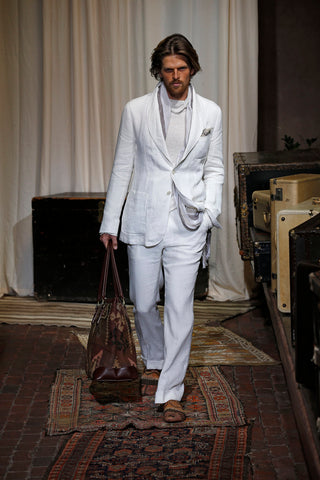 Model in Joseph Abboud's runway show wearing mens kilim loafers and carrying a kilim bag