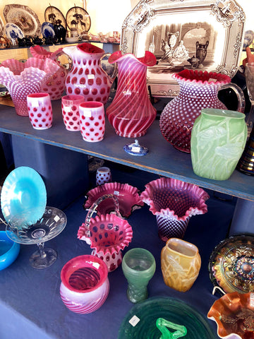 colorful assortment of vases and glass objects found at brimfield antique market.