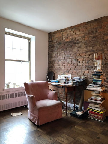 pauline's workspace at her studio, with pink velvet chair and desk. 