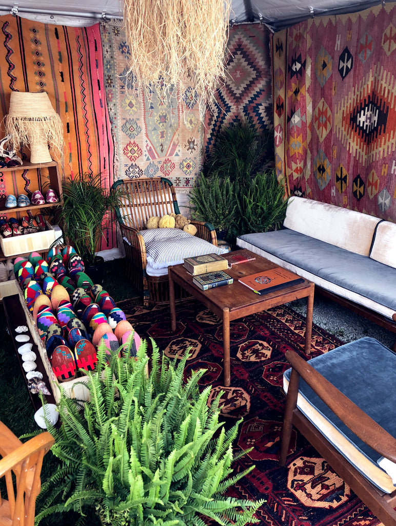 assortment of kilim smoking shoes, kilim loafers and velvet loafers displayed at Brimfield Antique Show on kilim carpet.