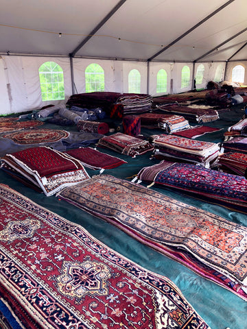 assortment of kilim carpets at brimfield antique market.