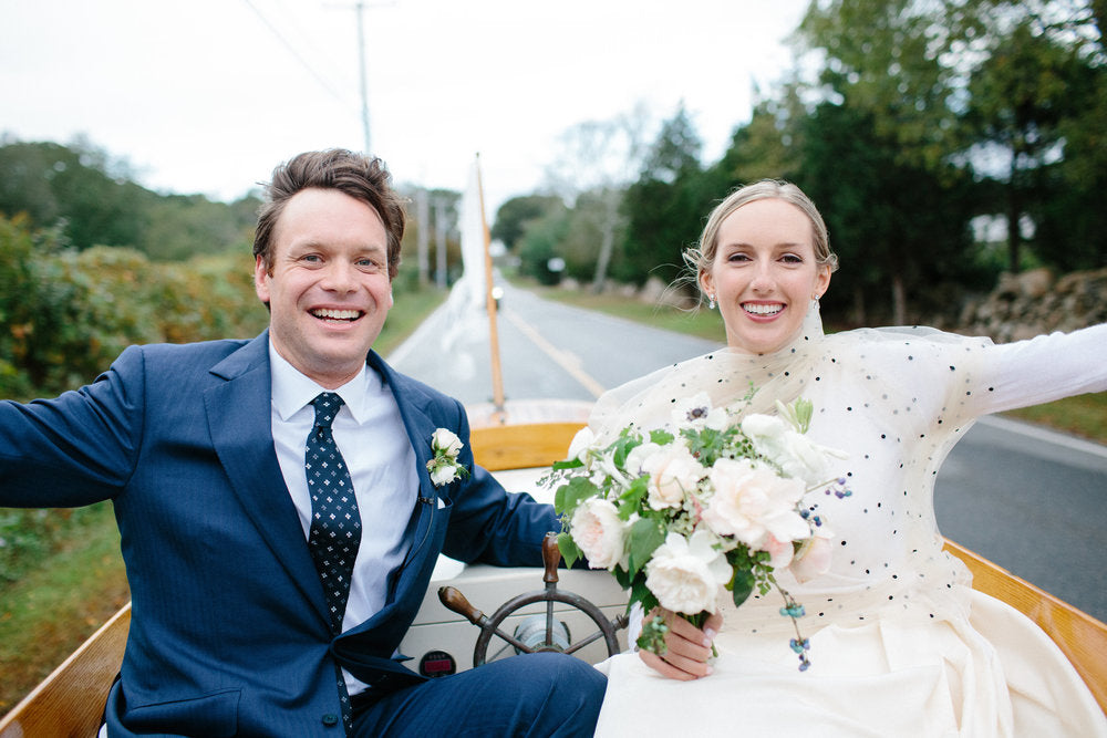 Bride and groom leaving the ceremony in a vintage boat. 