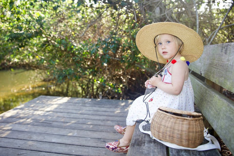 Madeline in colorful pom pom hat and in sumak kilim loafers, part of childrens shoes collection.