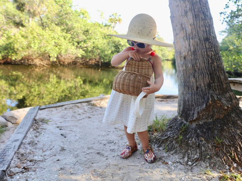 Madeline in colorful pom pom hat by lake and in sumak kilim loafers, part of childrens shoes collection.