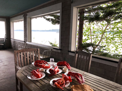 porch in Maine with lobster setting next to lake.