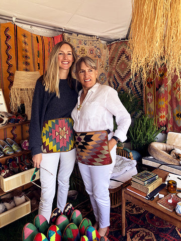 artemis team in kilim aprons and womens kilim loafers surrounded by kilim carpets and mens kilim loafers at brimfield antique market.