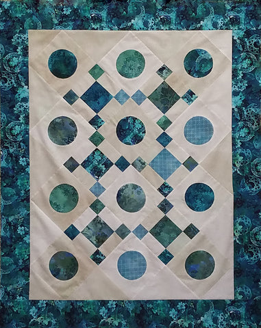 Teal-blue circles and squares are set on a cream background in this quilt by Jackie Vujcich of Colorado Creations Quilting.  Jackie teaches classes on making this technique simple