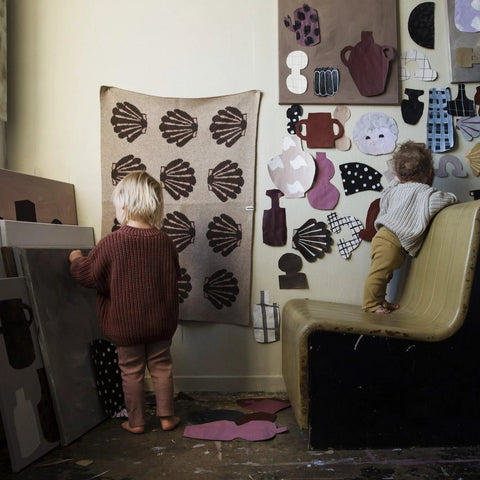 Two toddlers playing in a studio with Emilia Ilke x Jordling Home wool blankets