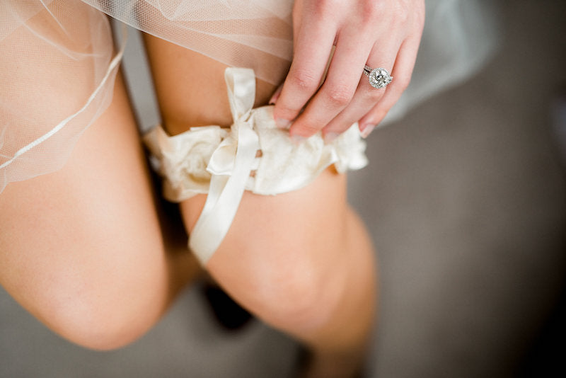 bride putting on elegant garter