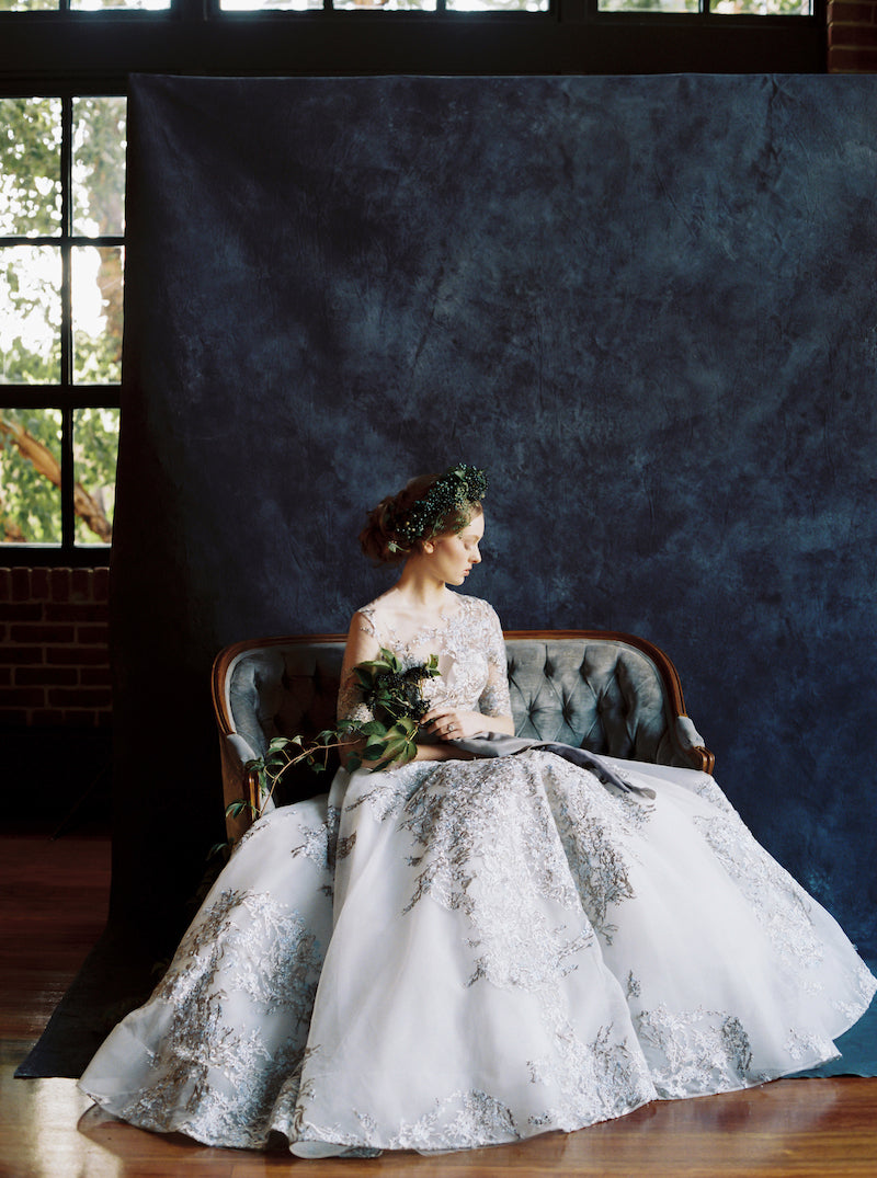 bride on dusty blue velvet couch