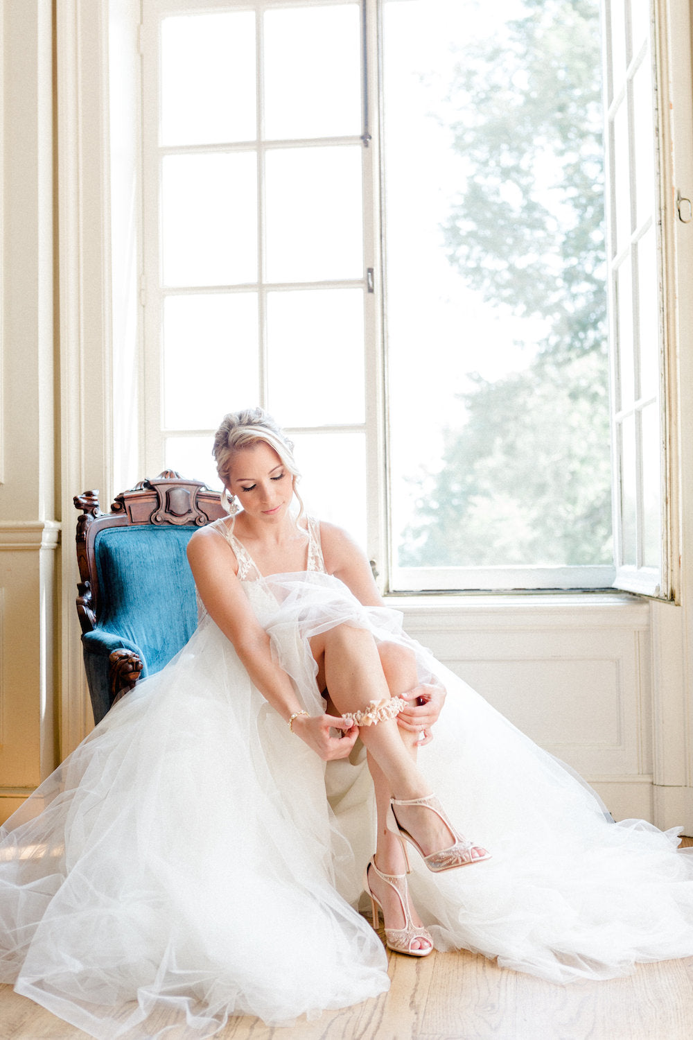 bride putting on garter - tips about trying wedding dresses on at home from The Garter Girl