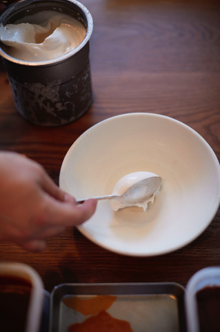 Spooning fresh ice cream into bowl