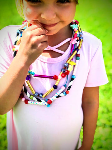 Girl wearing a bead and straw DIY necklace