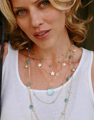 photo of model wearing shari wacks jewelry gold necklace layering star blue quartz pearl