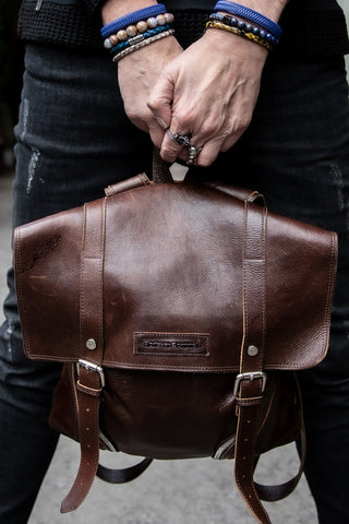man holding brown leather bag