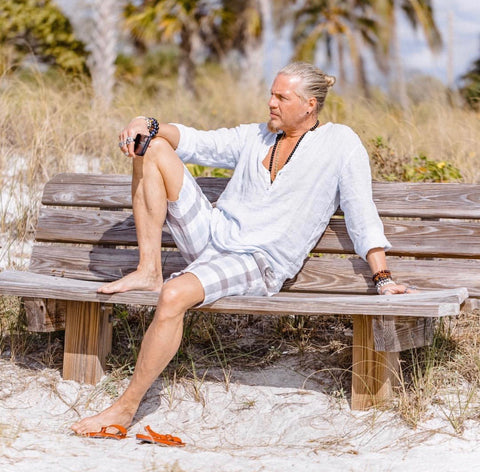 <img src="IMG-5863"alt="Caucasian male model sitting on bench on the beach">