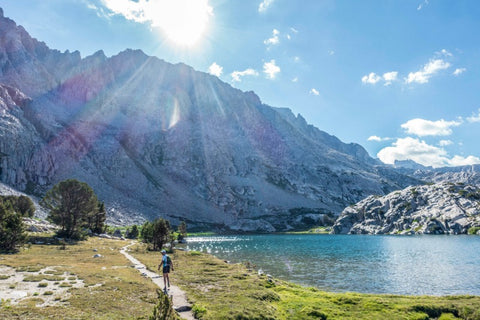 Mountainscape with trees lake and hiker