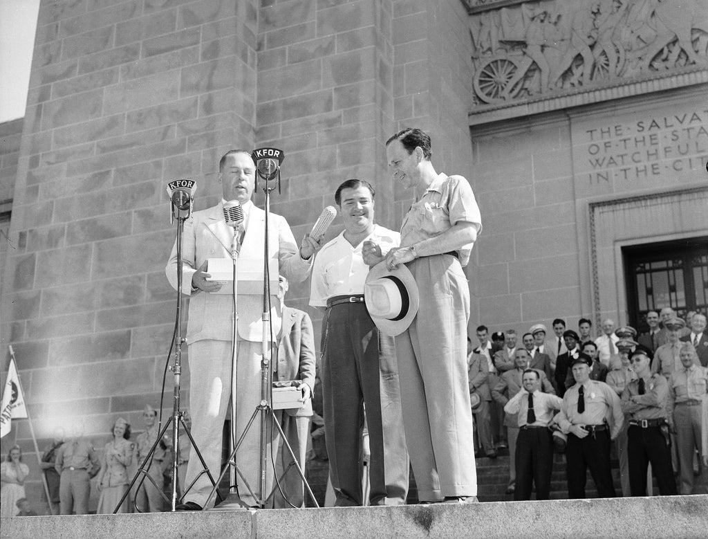 Comedians Bud Abbott and Lou Costello receive an ear of corn from Governor Dwight Griswold on the north steps of the State Capitol Building, July 31, 1942. -- Courtesy Nebraska State Historical Society / #RG2183.PH001942-000731-3