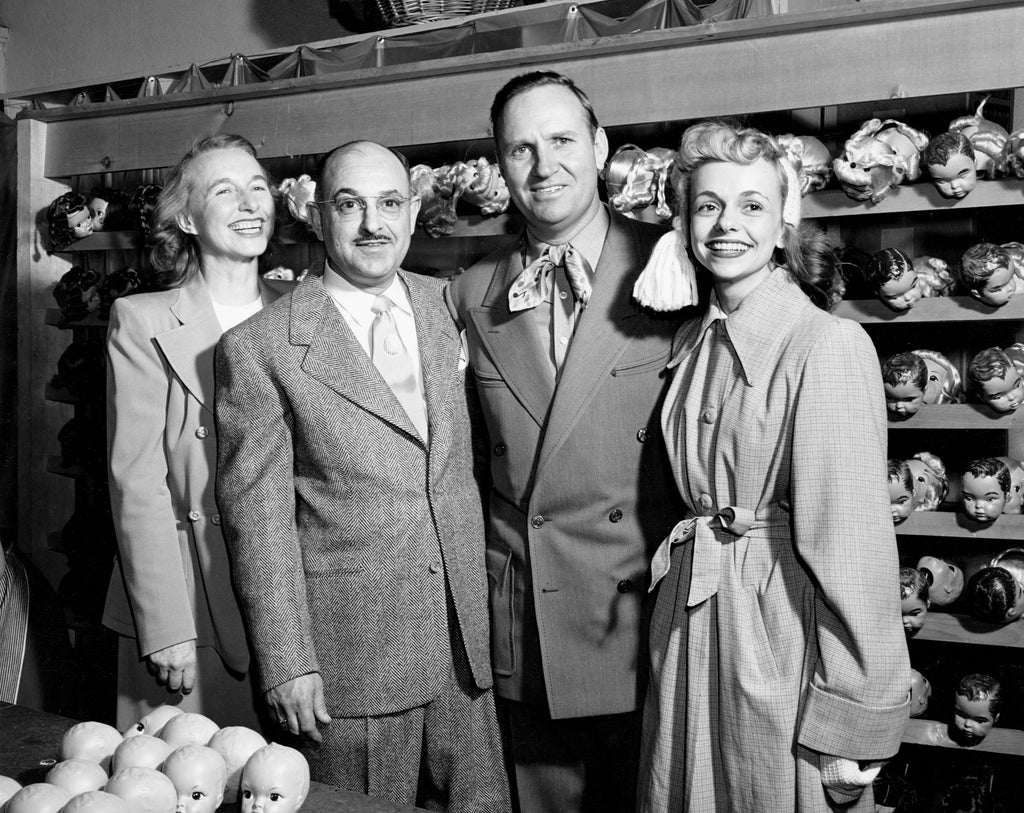 Violet Gradwohl, Harry Gradwohl, Gene Autry, and Terri Lee Schrepel pause for a group photo at the Terri Lee Doll Company factory in Lincoln, circa 1949. -- Courtesy Nebraska State Historical Society / #RG5812.PH0-000042