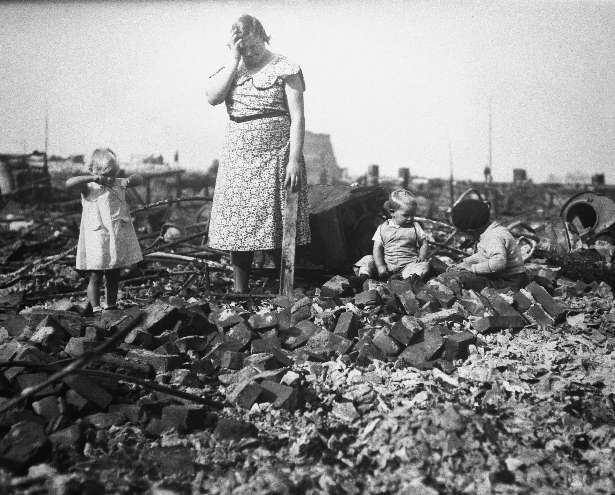 Grace Lawson with her children Dollie, Harry and Fritz search through the rubble of their home after the 1936 Bandon fire. -- Courtesy Coos History Museum & Maritime Collection / #992-8-2216