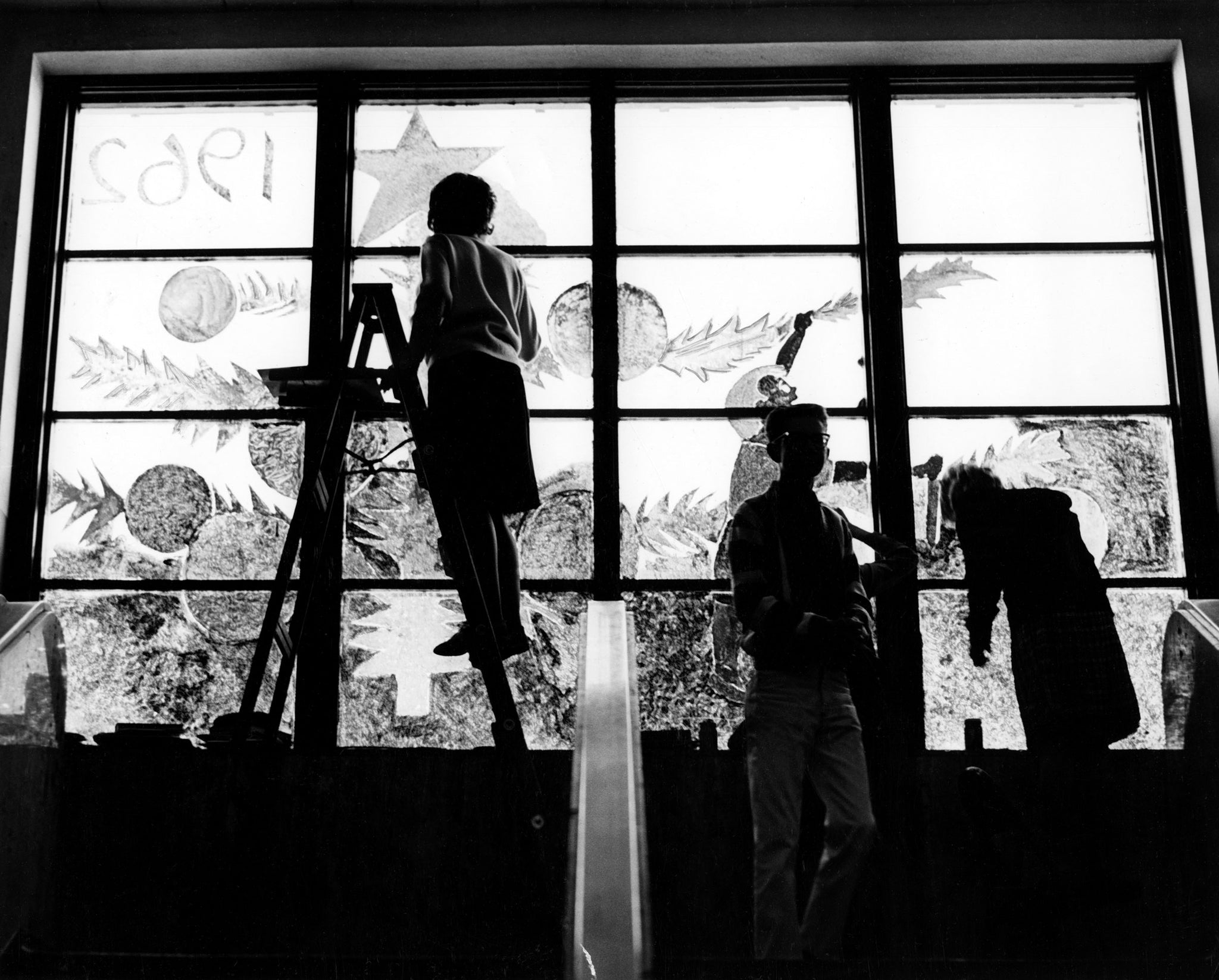 Students at Bismarck High School decorate a classroom window for the Christmas season, December 1962. -- Bismarck Tribune