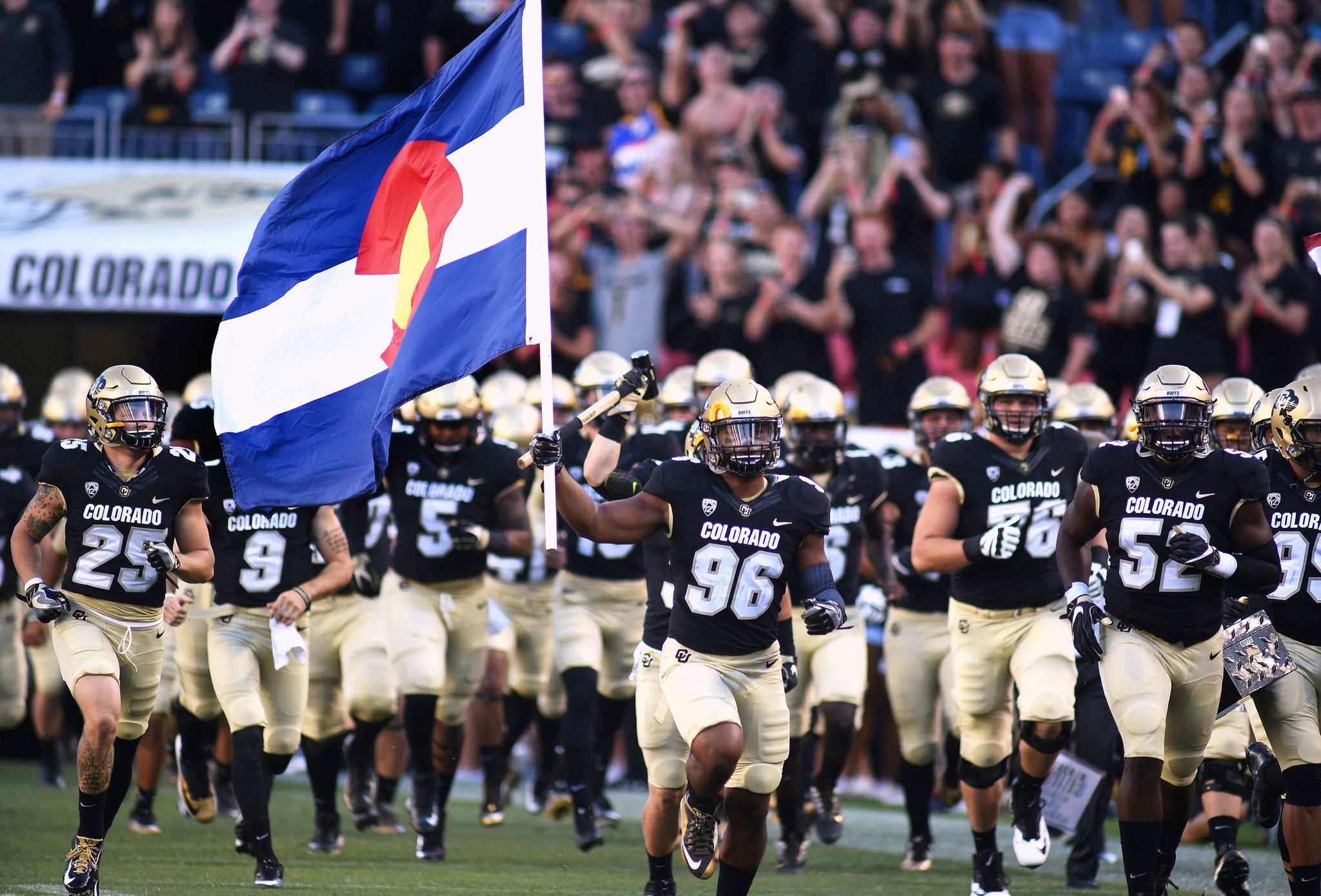 Terran Hasselbach carries out the Colorado State Flag before the Rocky Mountain Showdown. -- Cliff Grassmick