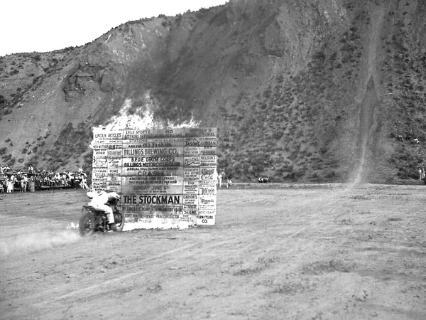 Billings Motorcycle Club stuntman crashing through a flaming barrier at 60 MPH during the first Indian Point hill climb event recognized by the American Motorcycle Association, June 5, 1938. -- Courtesy Fears-Salsbury Collection, Western Heritage Center
