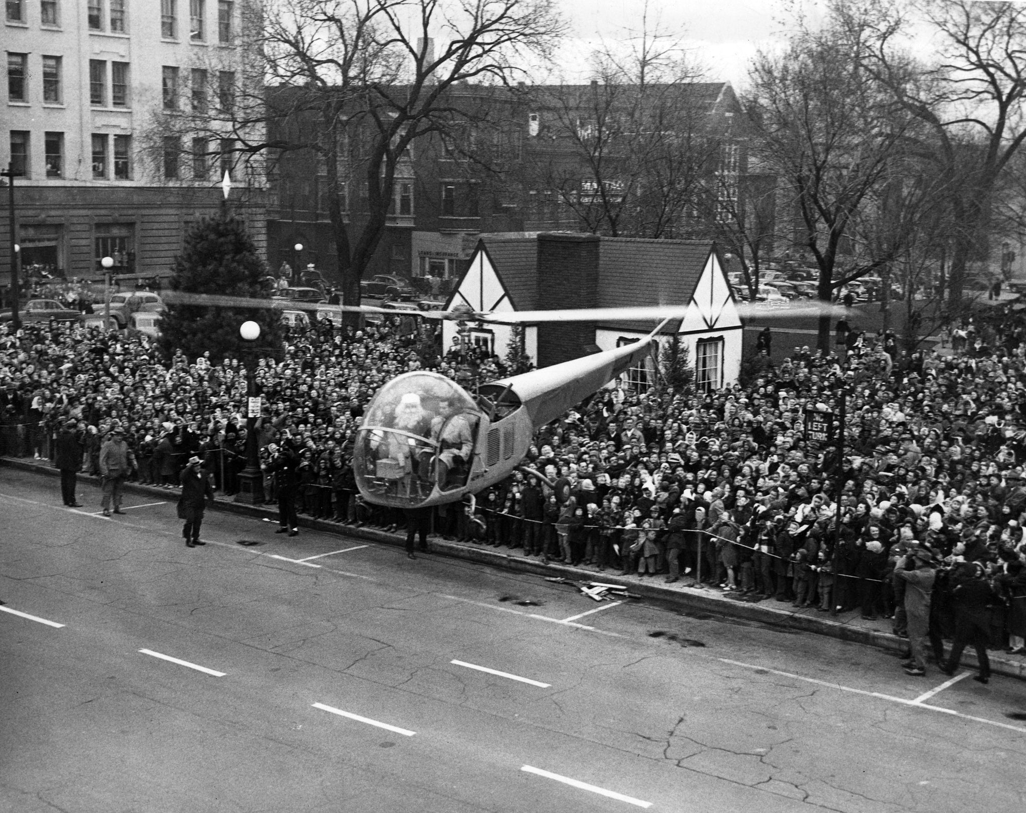 A crowd watching as Santa lands on Water Street in a helicopter, 1949. -- Herald & Review