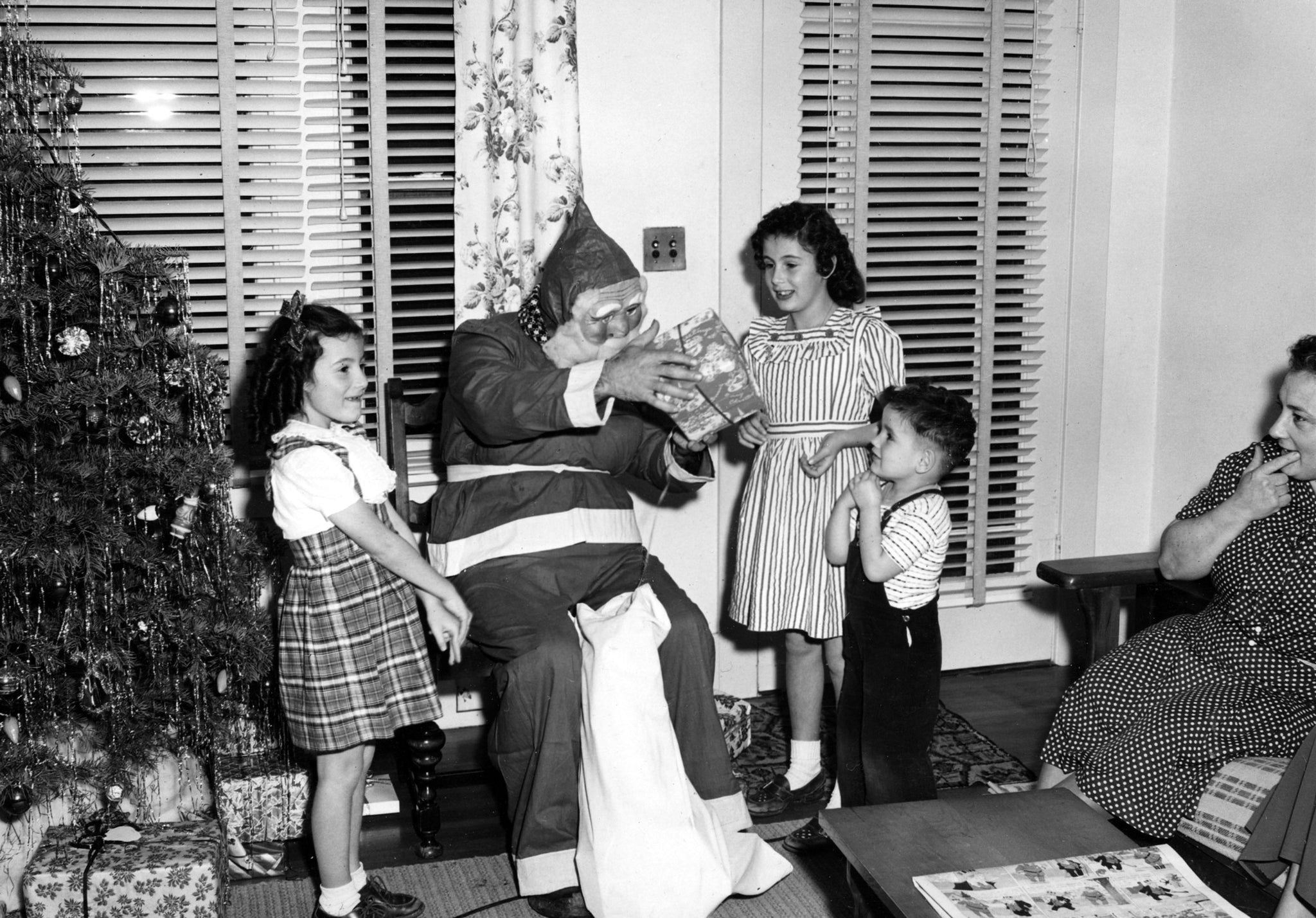 Santa visiting the Dias children on Christmas Eve, rural Modesto, 1948. From left: Marjorie Dias, Santa, Gloria and Ramond Dias. Mary Sequeira is on the right. -- Gloria Lewis