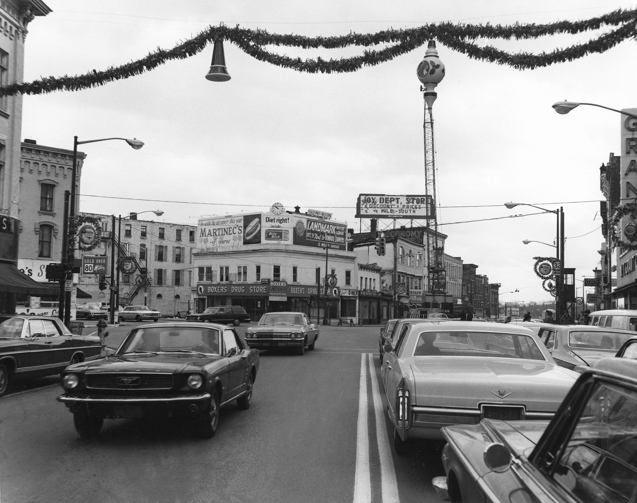 View down Glen Street toward Boxer’s Drug Store on the intersection of Glen and Warren Streets, November 1968. Note the Christmas decorations hanging above the street. -- Folklife Center at Crandall Public Library