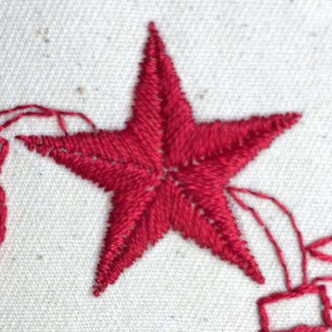 a hand embroidered star filled with satin stitch