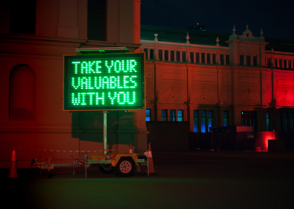 Neon sign: "Take your valuables with you"