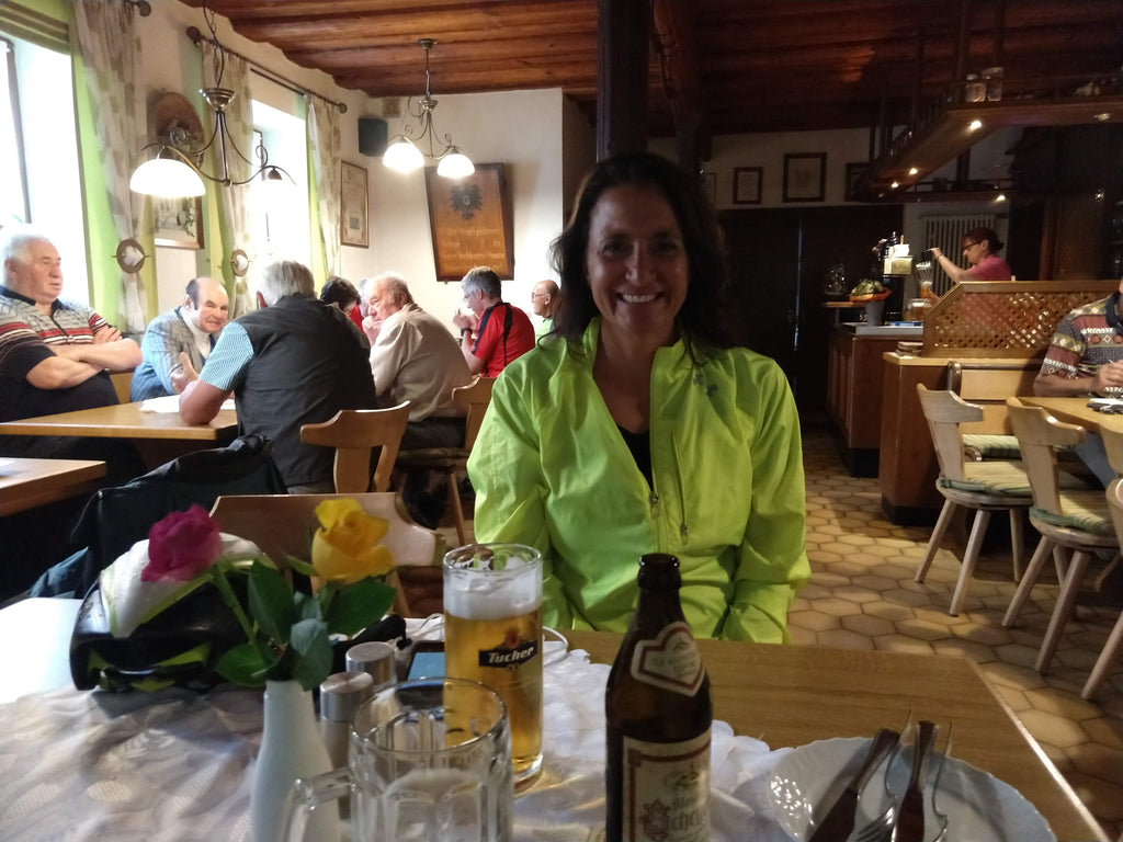 Photo of Maria smiling in a cozy restaurant with beer on the table in Bavaria