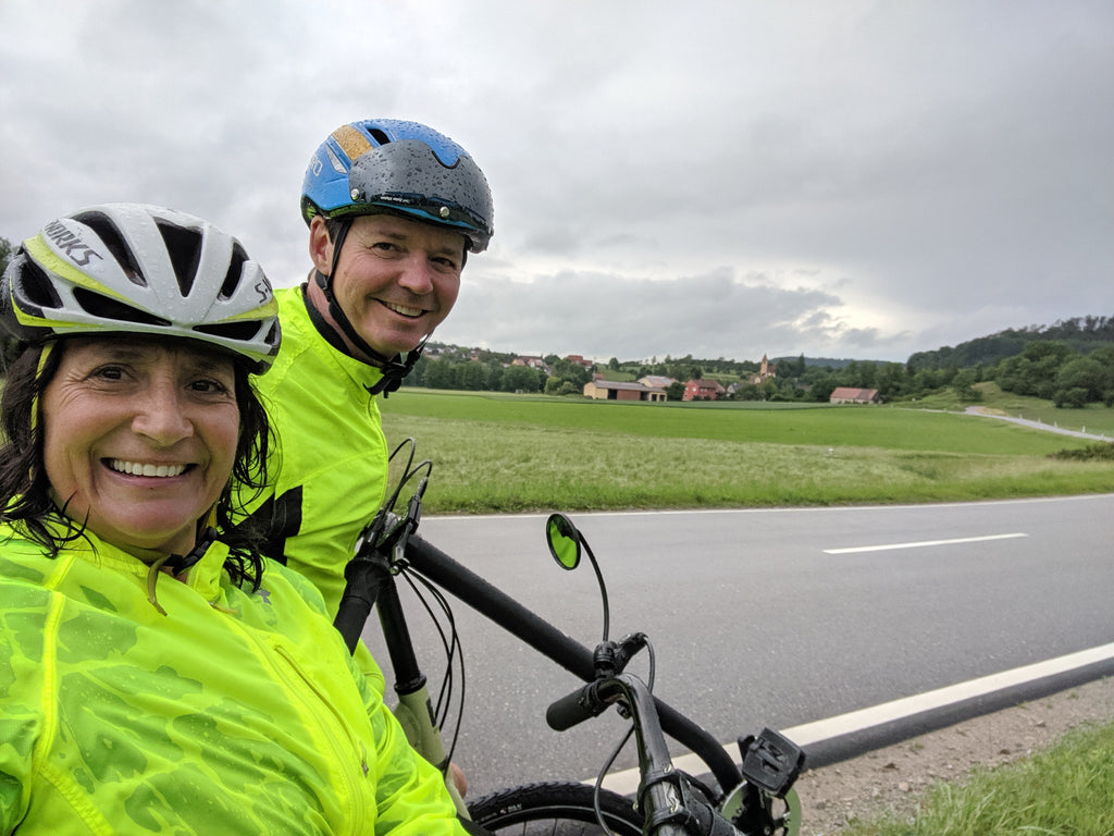 Photo of Jim and Maria grinning despite the rain in the beautiful Bavarian countryside